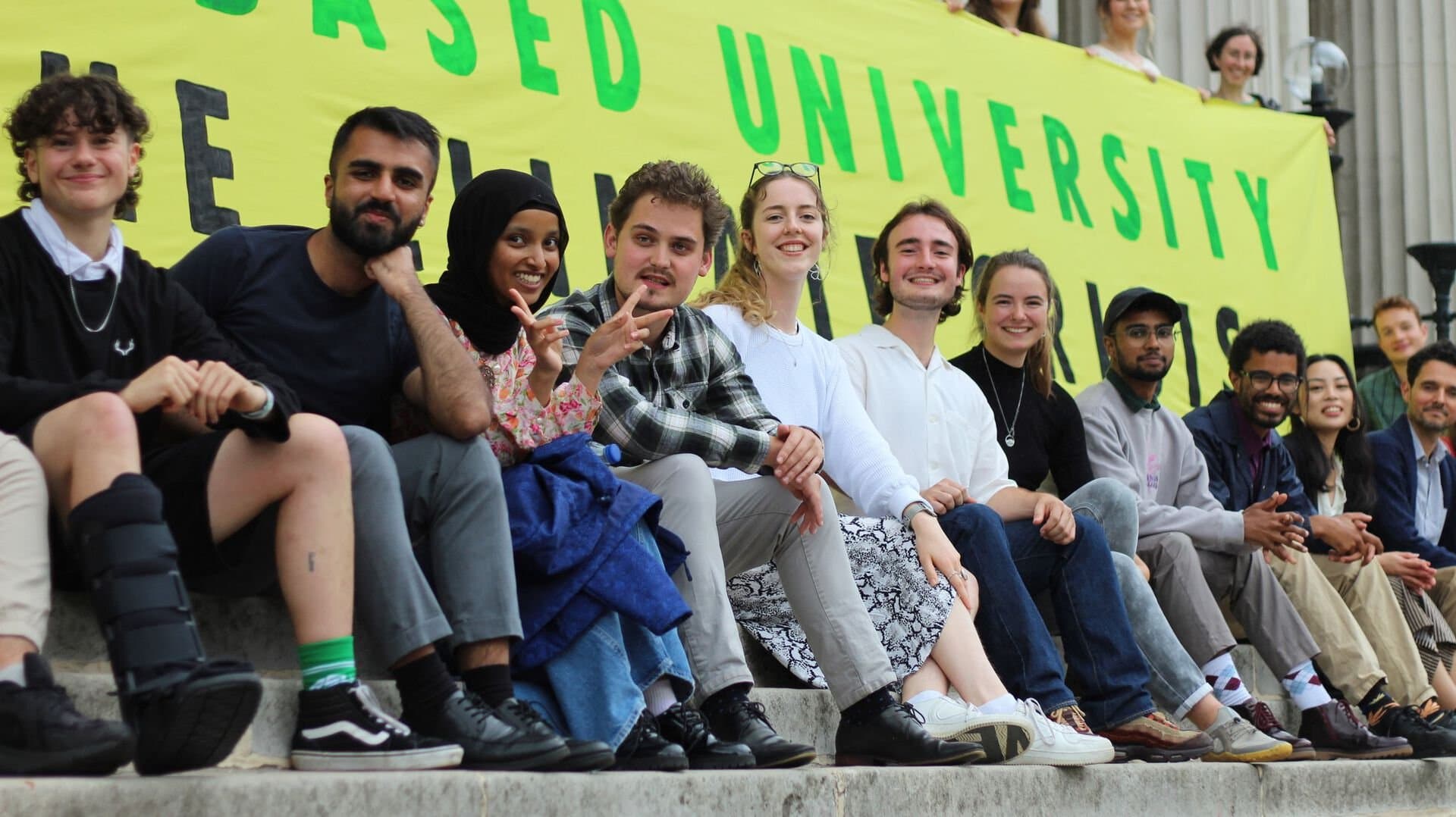 Student campaigners sitting together in front of a Plant-Based University banner.
